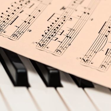 klaviertasten von nostalgischen notenblatt bedeckt