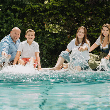 Familie Gass Oliver und melanie mit den kindern luca und sophie das thermalwasser aus dem pool in die kamera spritzend spaß und gute laune