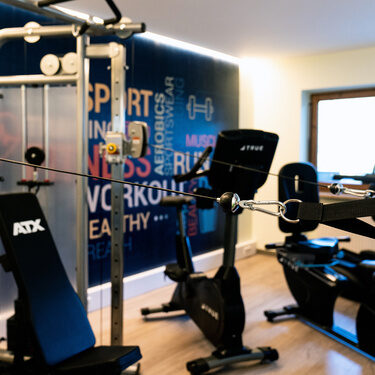 ein fitnessraum mit hantelturm ergometer modern gestaltet und tv für taegliches training