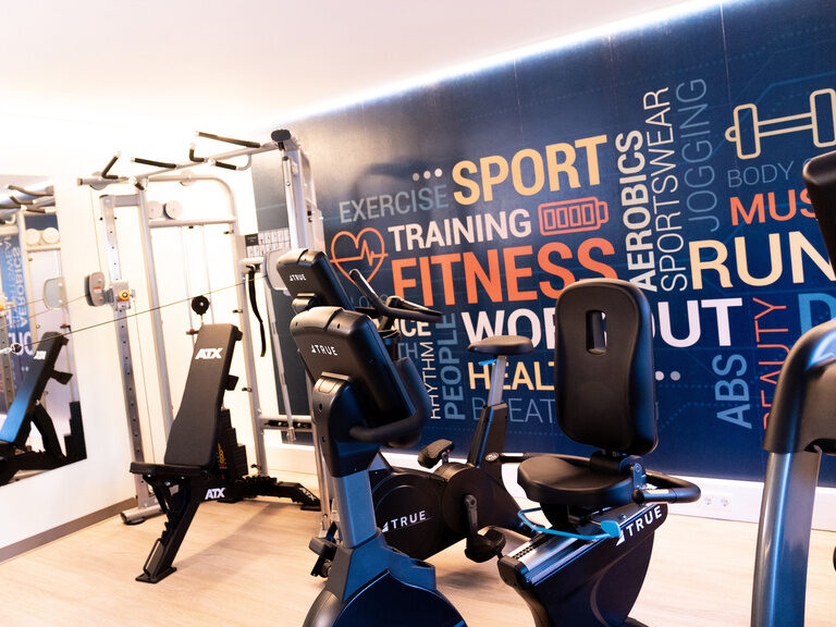 blick durch unserem fitnessraum ergometer hantelturm eine fototapete mit schriftzügen