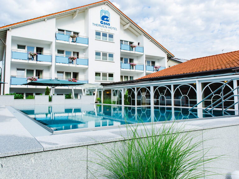 Detailaufnahme über dem pool mit blick zum hotel